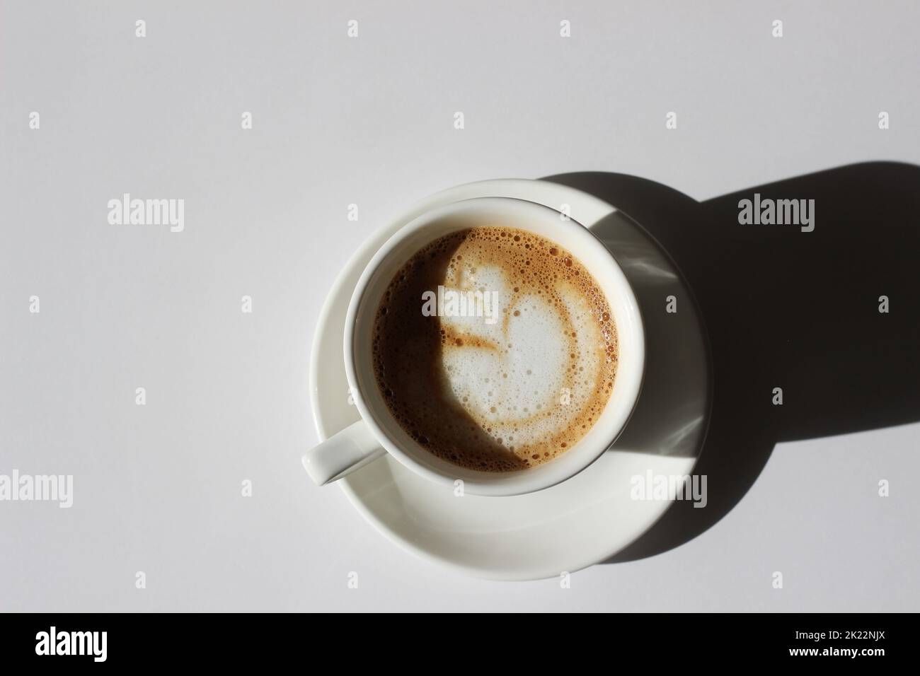 Cappuccino fraîchement préparé avec Latte Art en gros plan de la tasse Demitasse. Café du matin. Banque D'Images