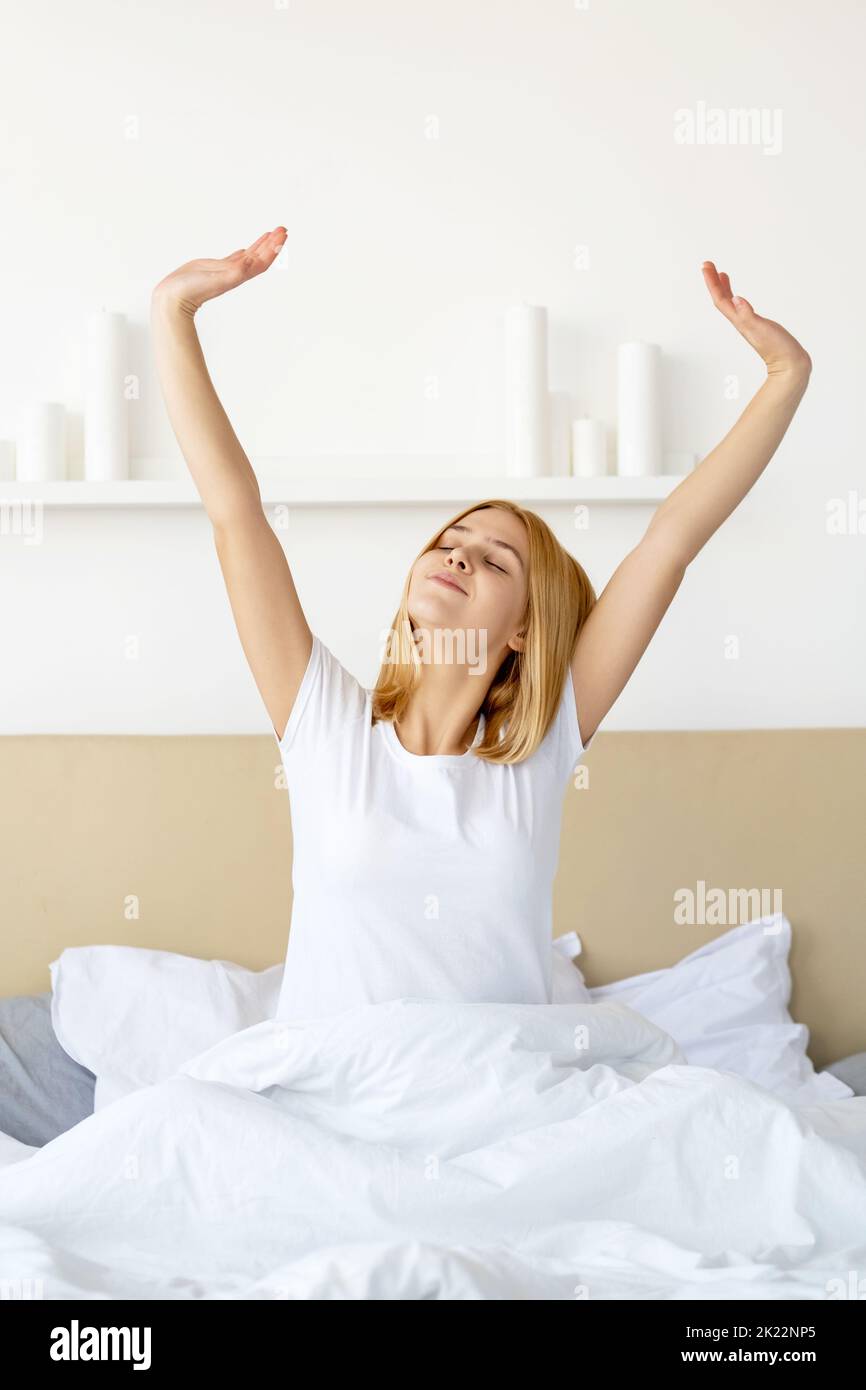 Bonne nuit de sommeil. Matin agréable. Repos bien-être. Nouveau jour. Réveil frais reposé heureuse femme s'étirant après se réveiller dans un lit doux avec draps blancs b Banque D'Images