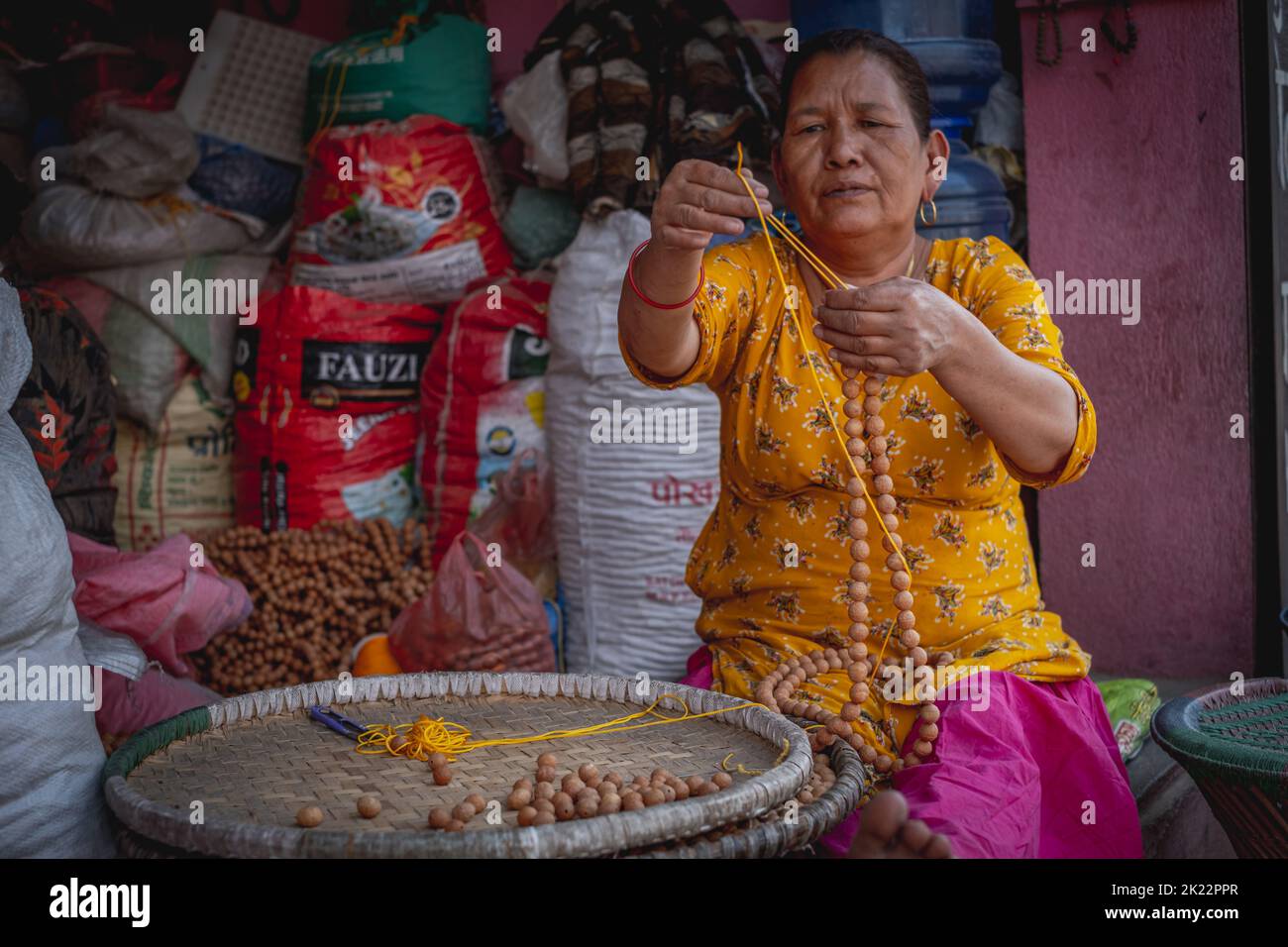 Une femme qui fait des perles à vendre près du temple du singe à Katmandou, au Népal Banque D'Images