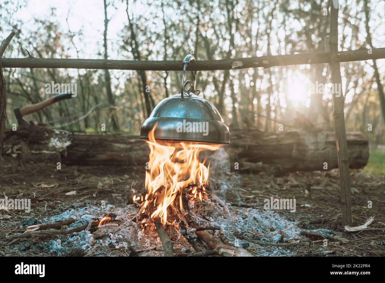La bouilloire est chauffée sur un feu de camp lumineux. Magnifique soirée ambiance de feu de camp. Voyage dans la forêt. Banque D'Images
