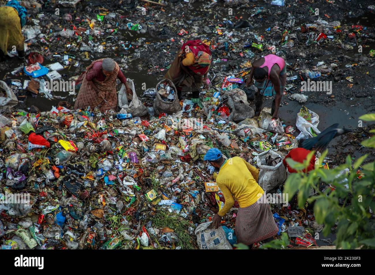 Les moyens d'existence des salariés à revenu très faible travaillant dans les zones polluées dangereuses du déversement de déchets de Chattogram dans Halishahar Chattogram. Les travailleurs collectent les matériaux recyclables de ces tas de déchets tout au long de la journée et les déposent dans des ateliers de ferraille. En tant que commerçants, ils travaillent ici toute la journée et prennent des risques sanitaires extrêmes. Chattogram, Bangladesh. Banque D'Images