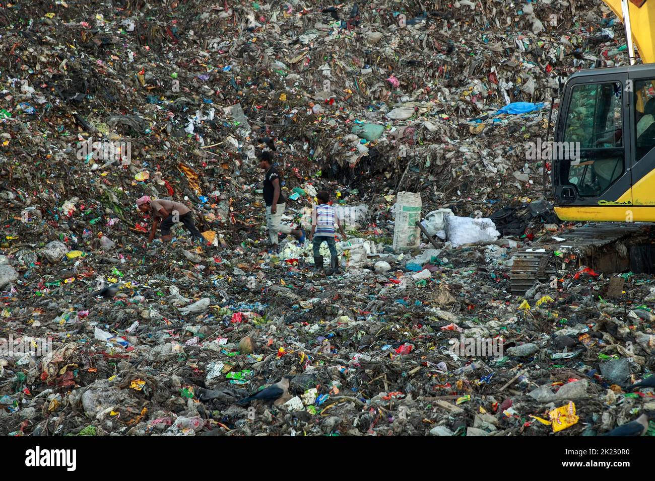 Les moyens d'existence des salariés à revenu très faible travaillant dans les zones polluées dangereuses du déversement de déchets de Chattogram dans Halishahar Chattogram. Les travailleurs collectent les matériaux recyclables de ces tas de déchets tout au long de la journée et les déposent dans des ateliers de ferraille. En tant que commerçants, ils travaillent ici toute la journée et prennent des risques sanitaires extrêmes. Chattogram, Bangladesh. Banque D'Images