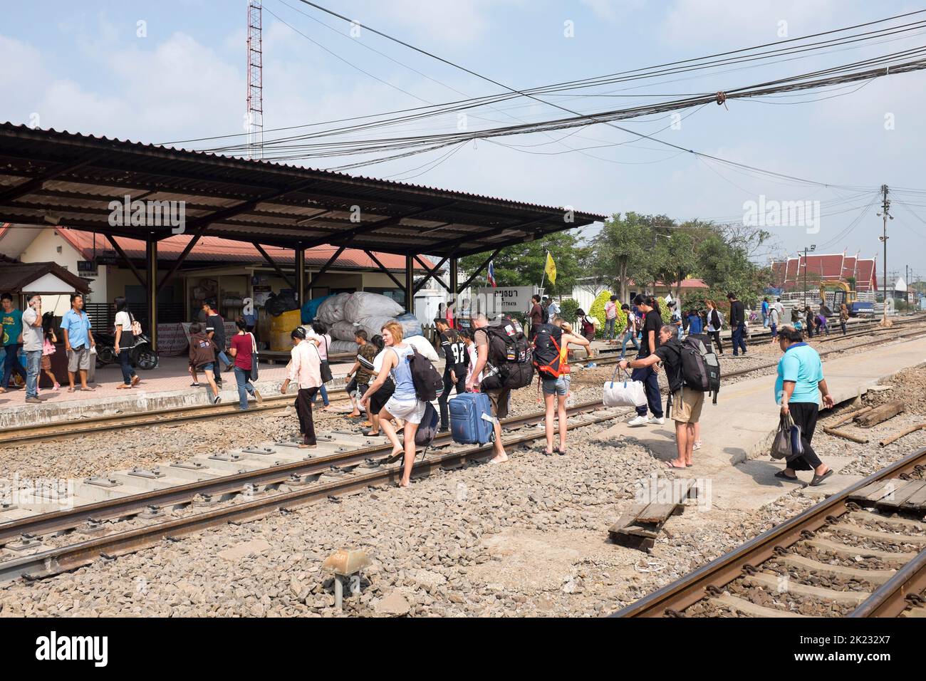 Passagers traversant les voies après leur arrivée à la gare d'Ayutthaya en Thaïlande Banque D'Images