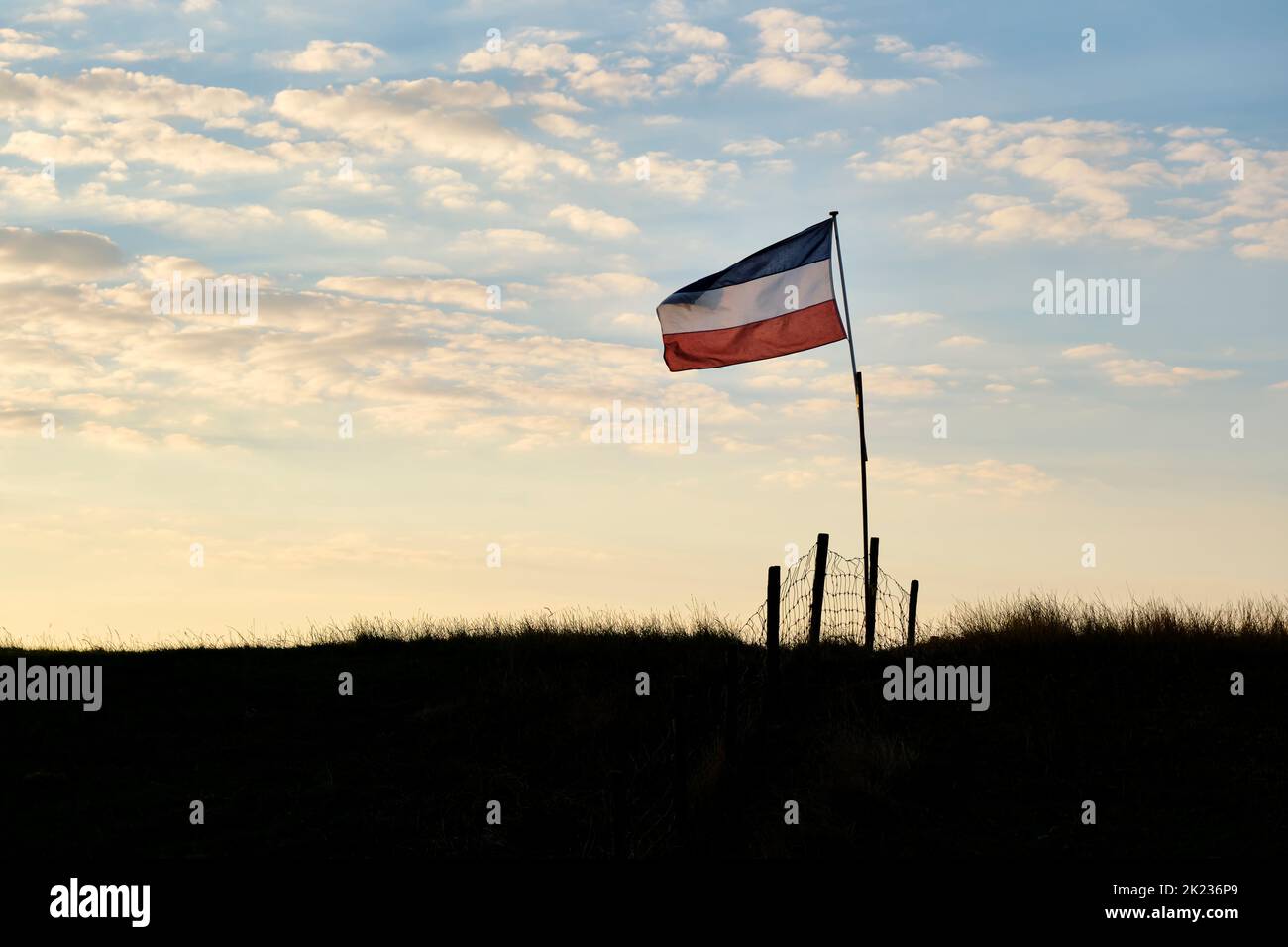 Drapeau bleu et blanc rouge néerlandais à l'envers sur une digue au coucher du soleil aux pays-Bas. Les agriculteurs des pays-Bas protestent. Banque D'Images