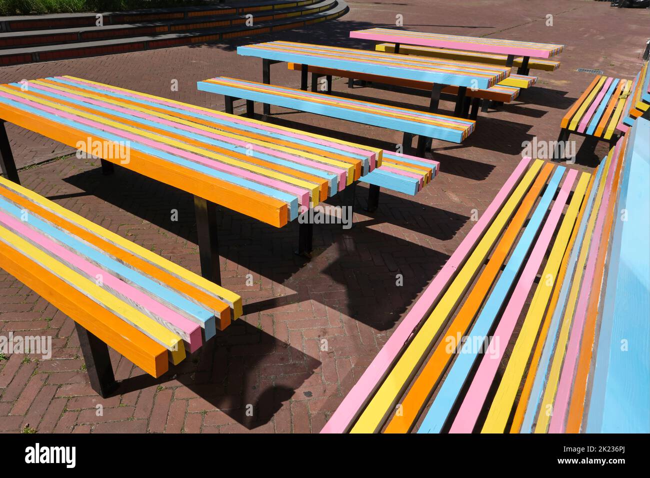 Tables et bancs extérieurs colorés sur la terrasse d'un café ou d'un restaurant de la ville en été. Mobilier d'extérieur orange, jaune, rose et bleu Banque D'Images