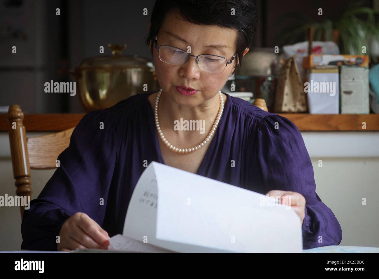 Sophie Luo Shengchun, épouse de l'avocat chinois des droits humains emprisonné, Ding Jiaxi, lit une lettre de lui chez elle à Alfred, New York, Etats-Unis, 28 juillet 2022. Pour égaler le rapport spécial CHINE-AVOCATS/RÉPRESSION-CONTINENT. REUTERS/Brendan McDermid Banque D'Images