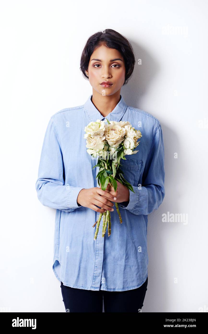 Shes la beauté parfaite. Studio photo d'une jeune femme ethnique attrayante tenant un bouquet de fleurs Banque D'Images