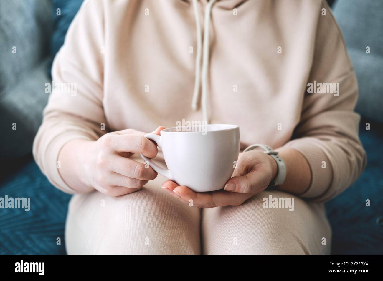 Soin de soi, séjour à la maison, ambiance chaleureuse. Prenez soin de vous, concept de l'amour de vous-même. Femme mains avec une tasse de boisson chaude à la maison Banque D'Images