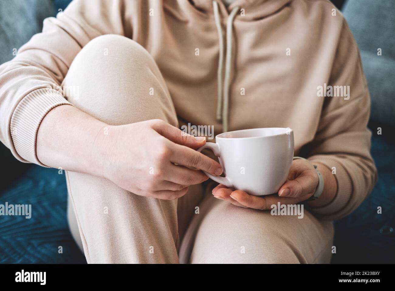 Soin de soi, séjour à la maison, ambiance chaleureuse. Prenez soin de vous, concept de l'amour de vous-même. Femme mains avec une tasse de boisson chaude à la maison Banque D'Images