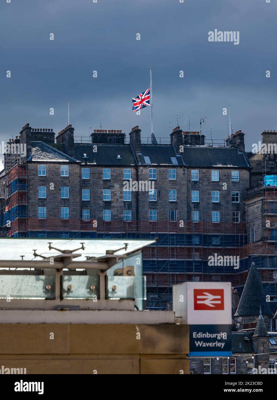 Drapeau Union Jack volant à mi-mât après la mort de HM Queen Elizabeth II sur le toit du bâtiment du centre-ville d'Édimbourg, Écosse, Royaume-Uni Banque D'Images