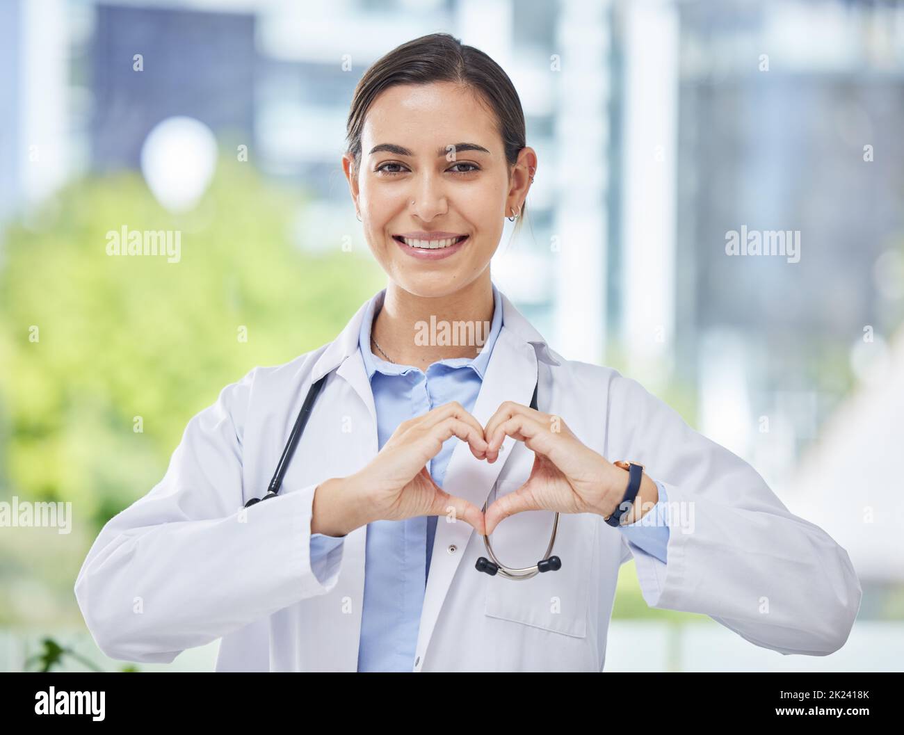 Cœur, main et icône avec un médecin heureux en clinique médicale ou à l'hôpital. Heureux, santé et sécurité dans le domaine de la médecine et des soins de santé tout en amour pour Banque D'Images