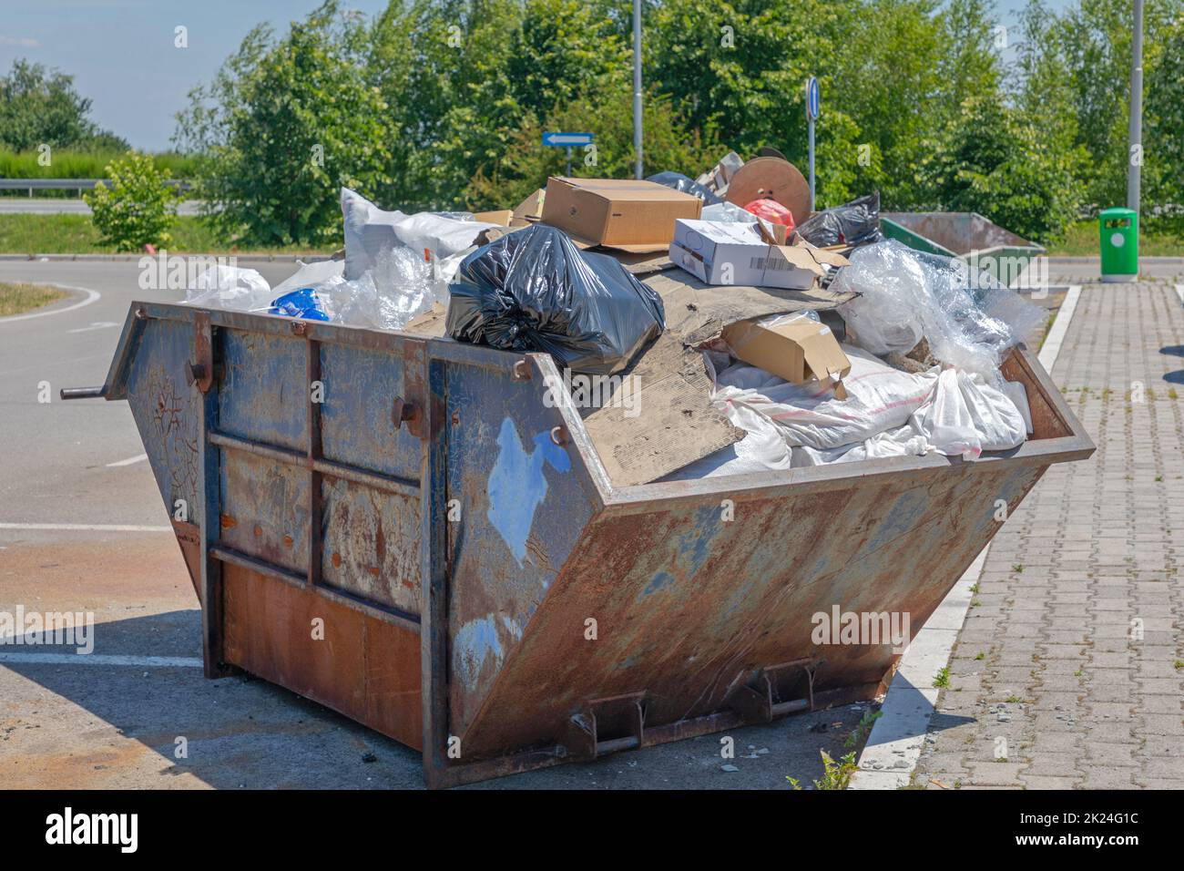 Conteneur de déchets Skip surchargé au parking Banque D'Images