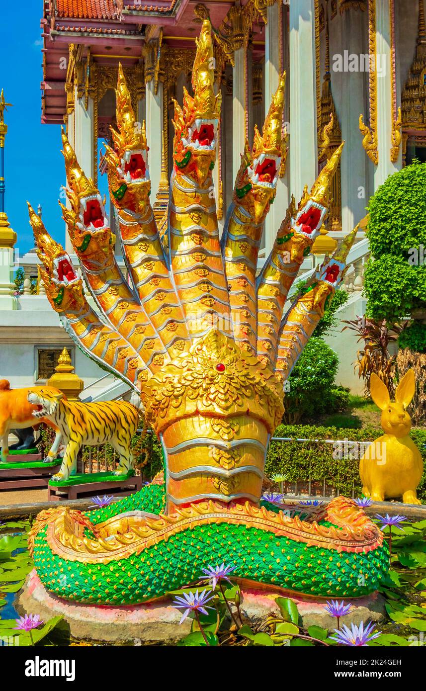 Dragons dorés et verts statues de libellules dans le temple bouddhiste Wat Don Mueang Phra Arramluang coloré à Bangkok en Thaïlande. Banque D'Images