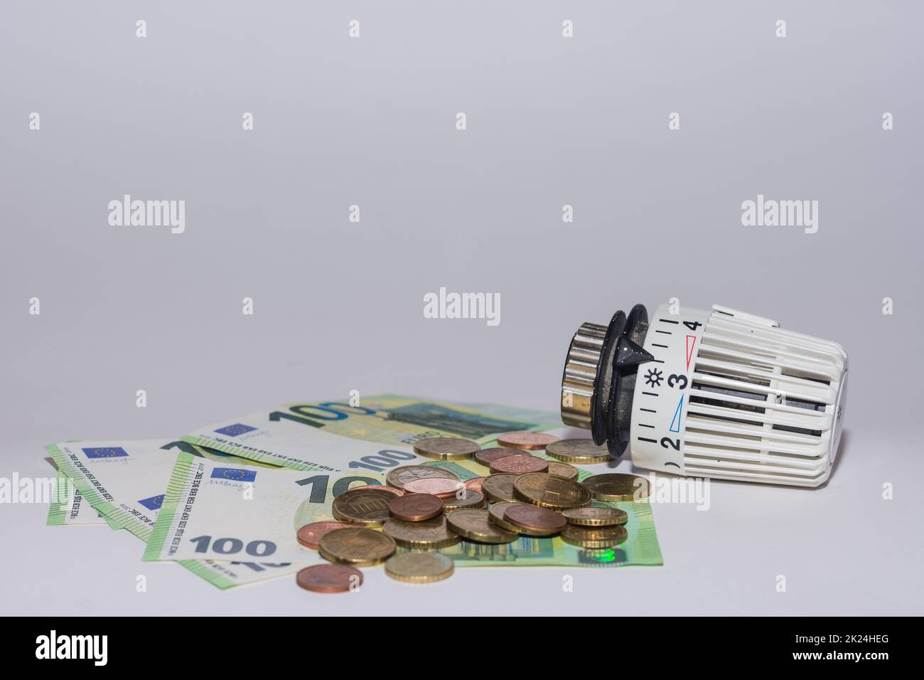 Les prix de l'énergie augmentent et la consommation d'énergie régulateur thermostatique du chauffage avec 100 euros factures et pièces de monnaie vue de dessous Banque D'Images