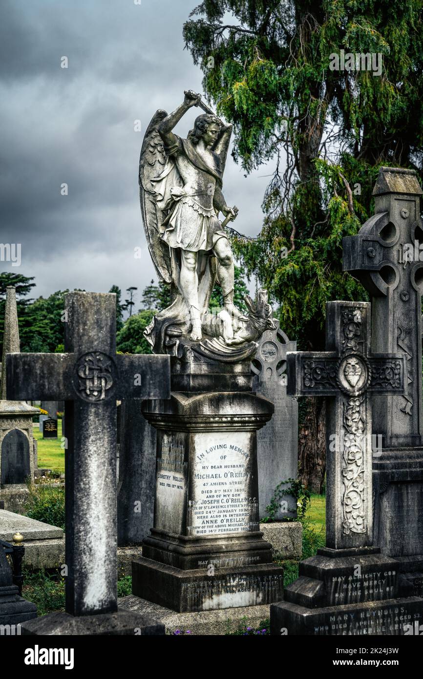 Dublin, Irlande, août 2019 Archange Michael comme un guerrier saint qui lasse un dragon, tombes avec des croix celtiques et des sculptures dans le cimetière Glasnevin Banque D'Images