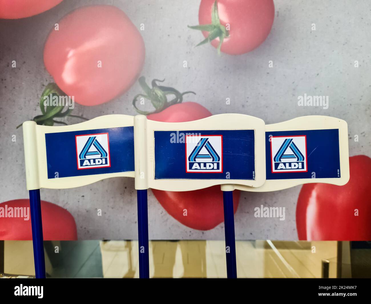 Kiel, Allemagne - 24.Fébulary 2022: Trois logos de l'escompteur Aldi devant une affiche avec des tomates fraîches Banque D'Images
