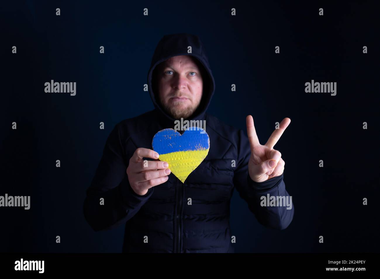 Drapeau de l'Ukraine en forme de coeur dans les mains des femmes. Le concept de solidarité avec les citoyens de l'Ukraine. Banque D'Images