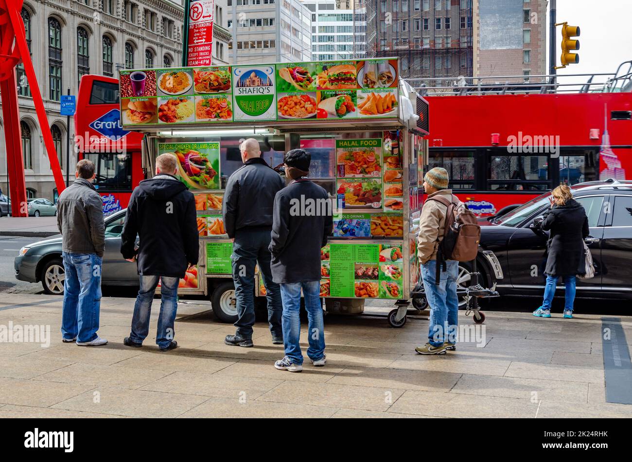 Les gens qui attendent en file d'attente devant le camion alimentaire Shafiq's Halal Street, debout sur un trottoir dans Manhattan vue arrière, New York City, pendant l'hiver, horizontal Banque D'Images