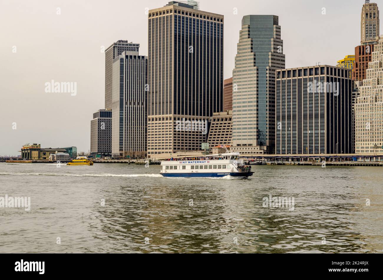 NY Waterway White Ferry devant le Skyline de Manhattan à East River dans la soirée, New York City, en hiver, horizontal Banque D'Images