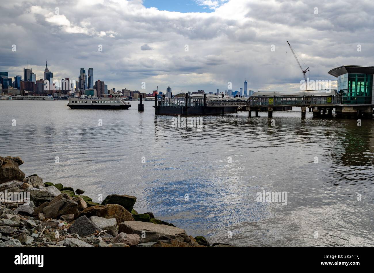 Port Imperial / Weehawken Ferry terminal à Hudson River, New Jersey avec ferry, vue latérale pendant la journée d'hiver nuageux, horizontal Banque D'Images