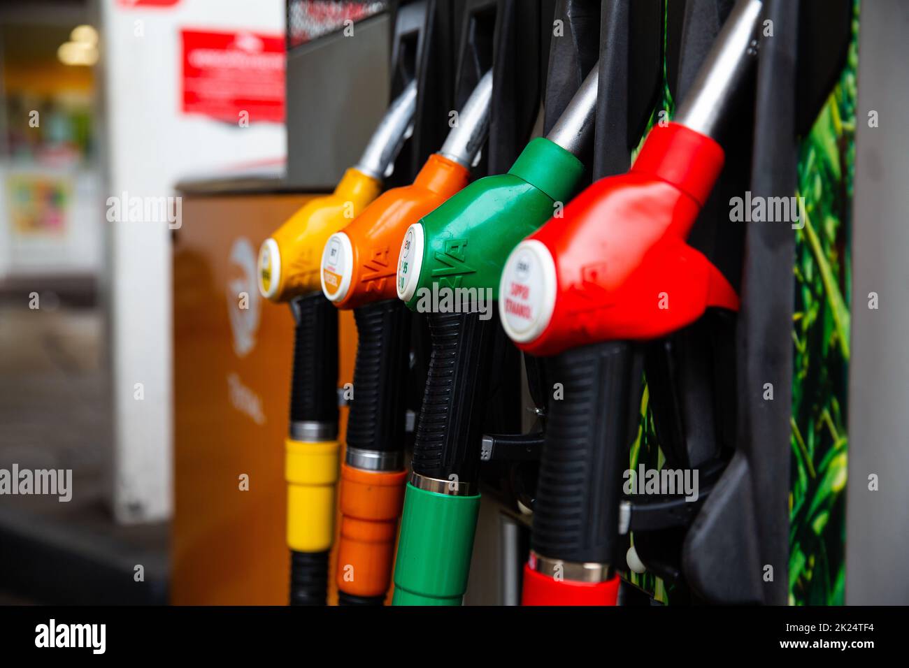 Gros plan sur la buse de carburant dans le distributeur d'huile avec de l'essence et du diesel dans la station-service. Bleu, vert, rouge, doré. Banque D'Images