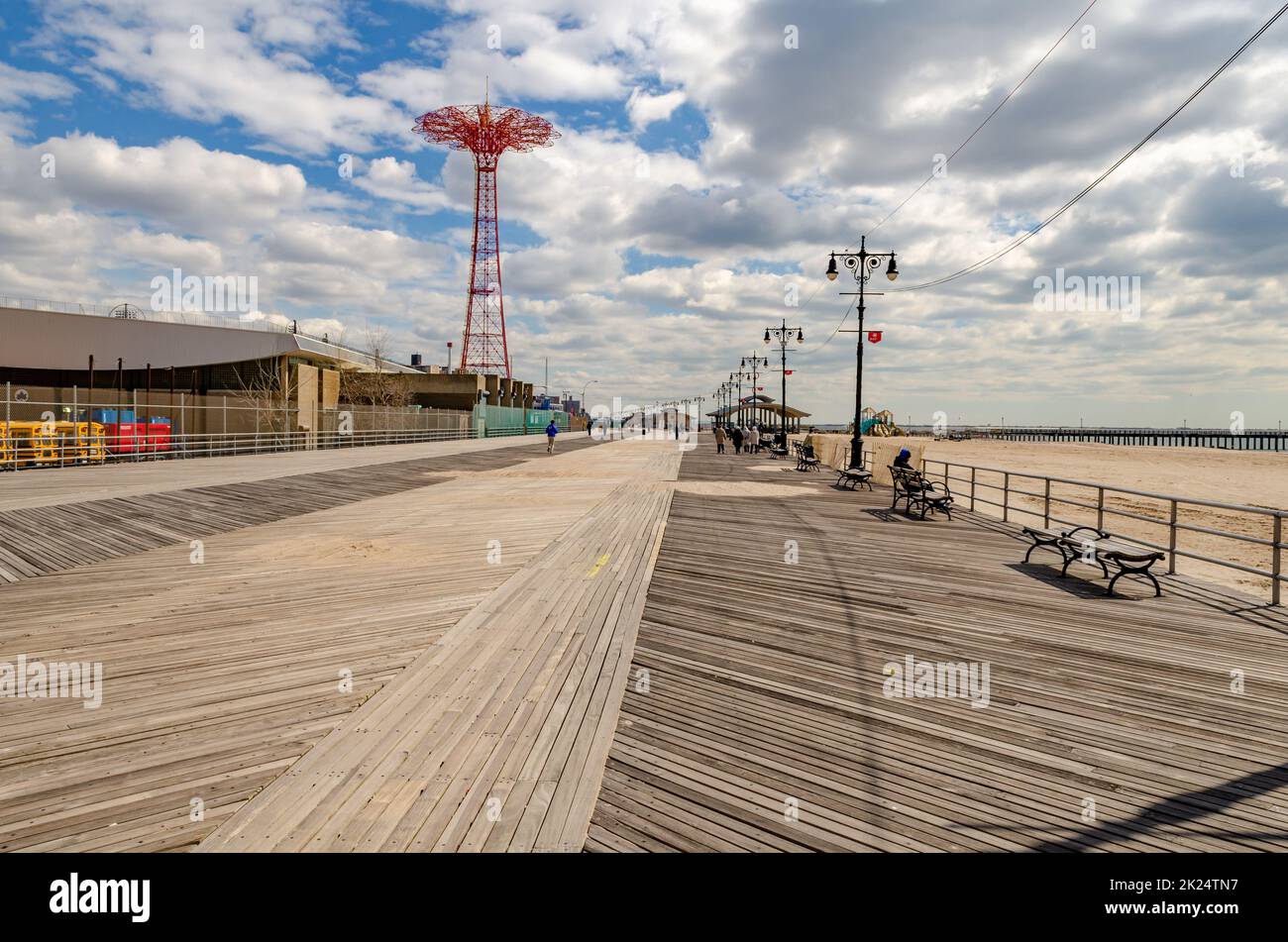 Promenade sur la plage avec saut en parachute rouge, parc d'attractions Luna Park à Coney Island, Brooklyn, New York City pendant la journée d'hiver ensoleillée avec ciel nuageux, PE Banque D'Images