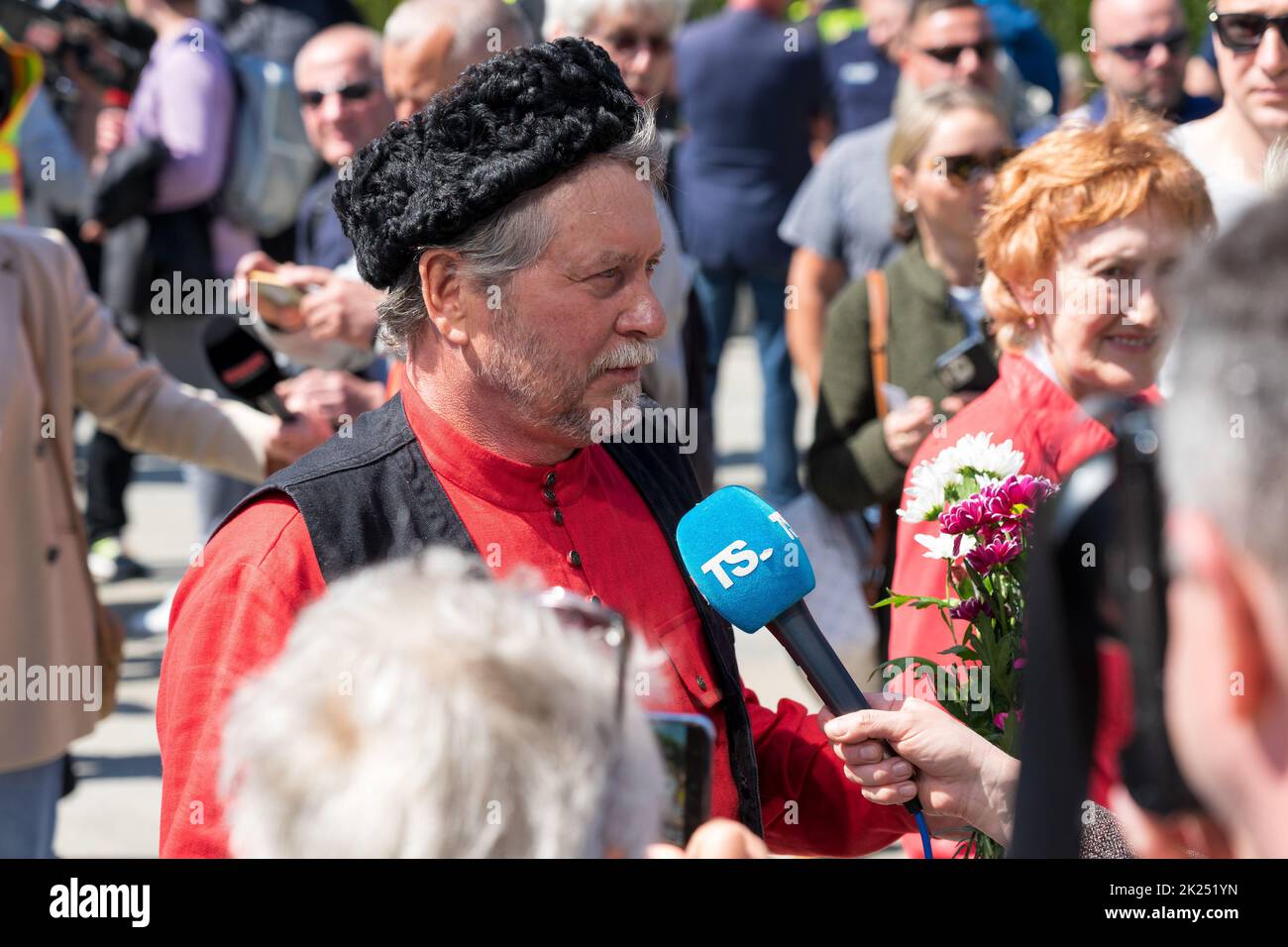 BERLIN - 09 MAI 2022 : jour de la victoire dans le parc Treptower. Un visiteur du mémorial militaire en vêtements cosaques traditionnels donne des interviews aux journalistes Banque D'Images