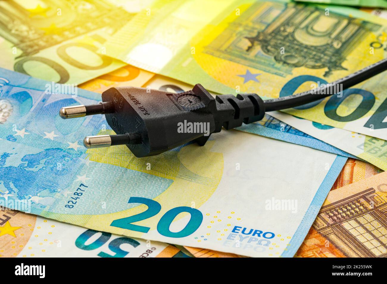 Fiche électrique noire sur les billets en euros. Augmentation du coût de l'électricité pour les clients résidentiels et les utilisateurs professionnels. Paiement des factures d'électricité. Lever Banque D'Images