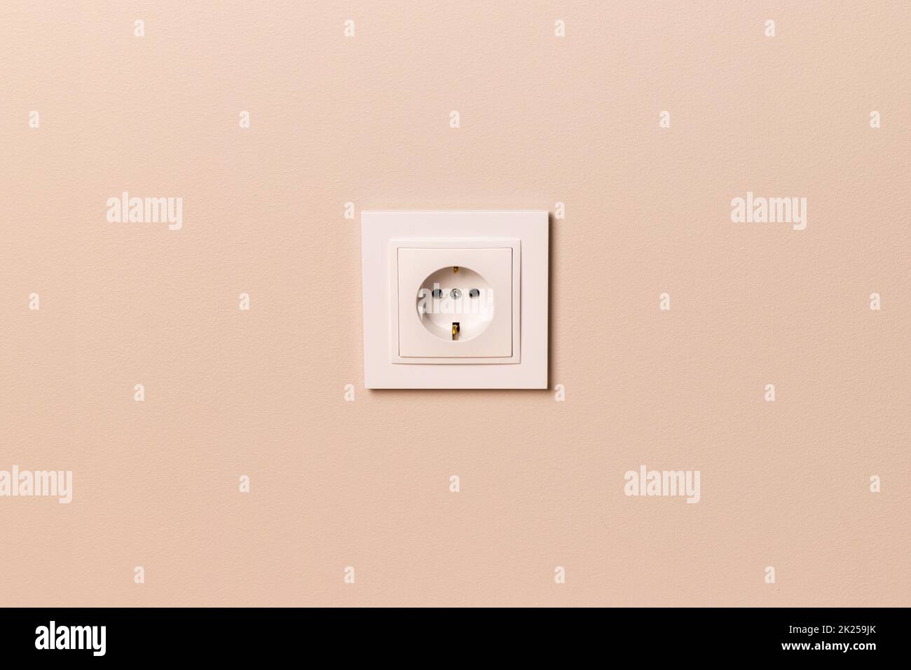 Prise électrique européenne blanche sur un mur beige moderne Banque D'Images
