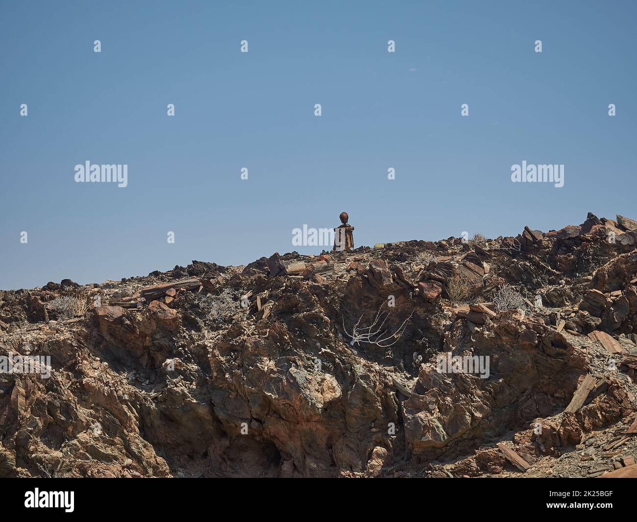 Kaokoveld, Namibie - 11 03 2016: Sculpture de roche de l'homme seul assise sur le côté de la route à Nambia Banque D'Images