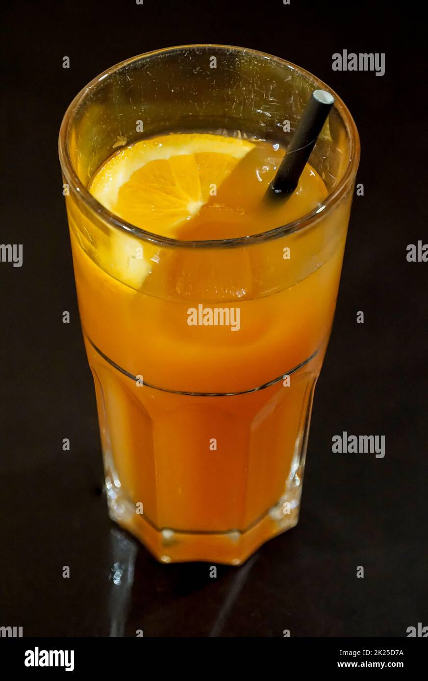 Un verre de jus d'orange sur fond sombre. Banque D'Images