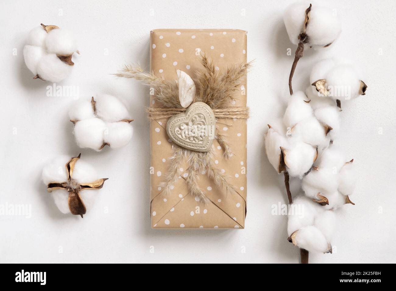 Cadeau de Saint-Valentin décoré de coeur et d'herbe de pampass près des fleurs de coton Banque D'Images