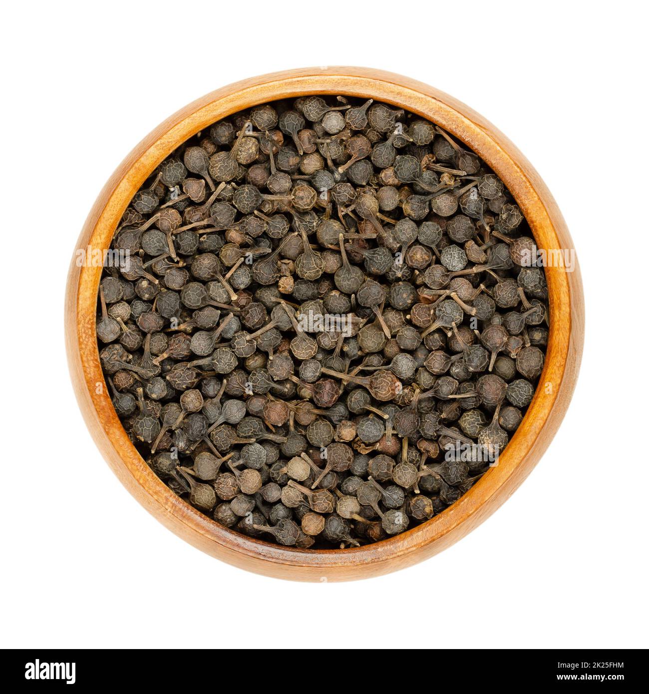 Baies de cubes, poivre de queue ou poivre de Java, dans un bol en bois Banque D'Images