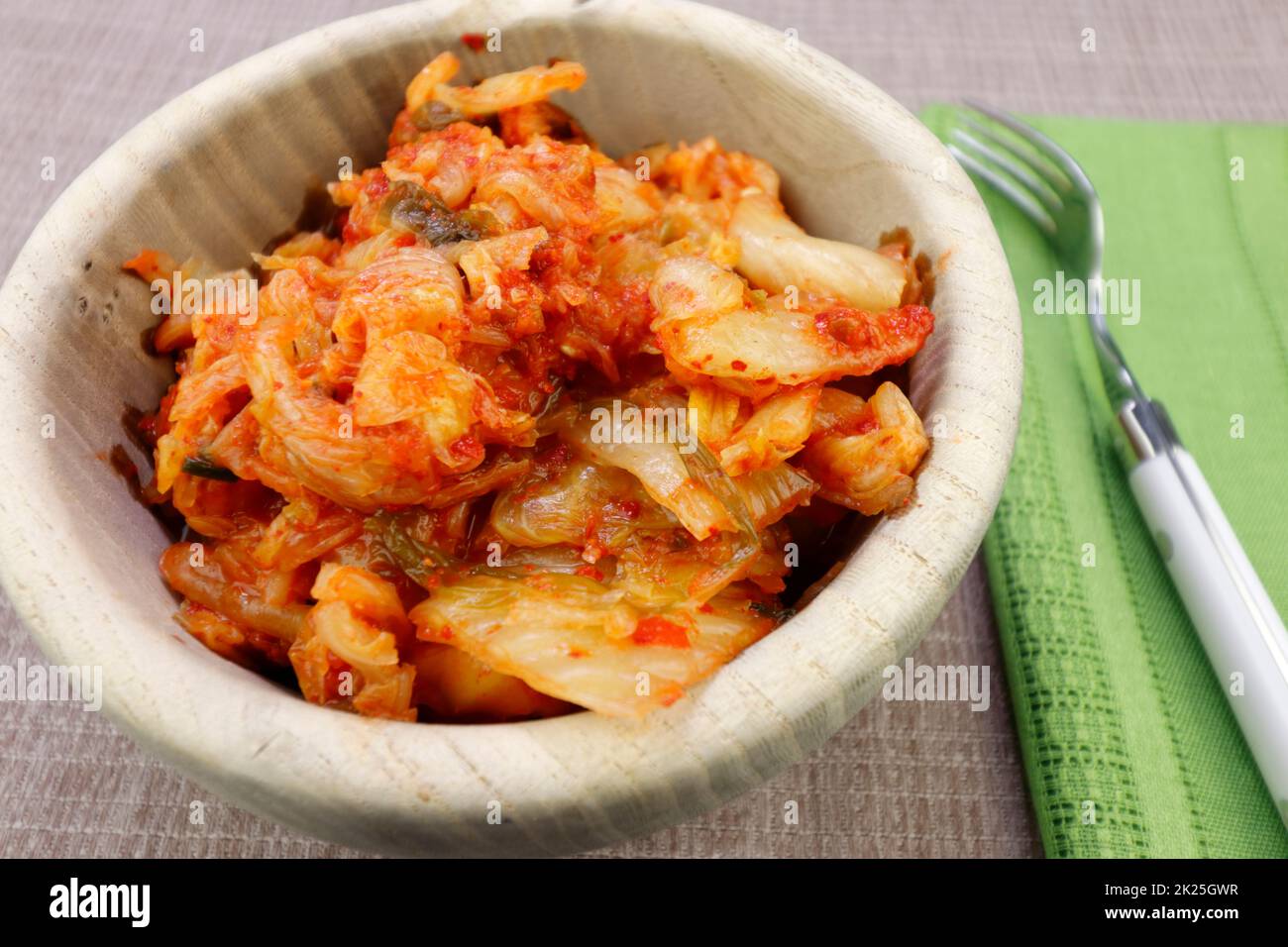 Kimchi prêt-à-manger épicé dans un saladier rond en bois en gros plan Banque D'Images