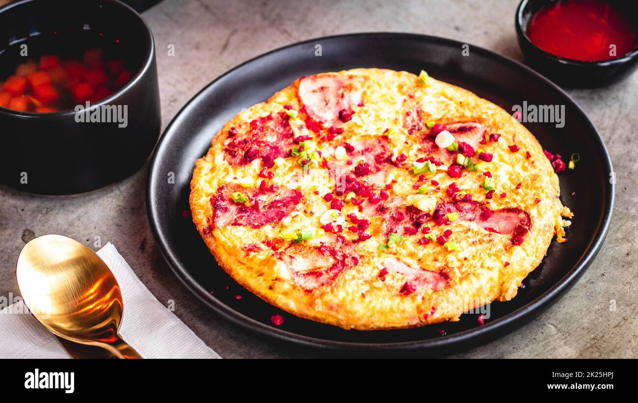 Omelette espagnole Frittata faite d'œufs bacon paprika persil pois vert oignon fromage pour la nourriture délicieuse. Banque D'Images