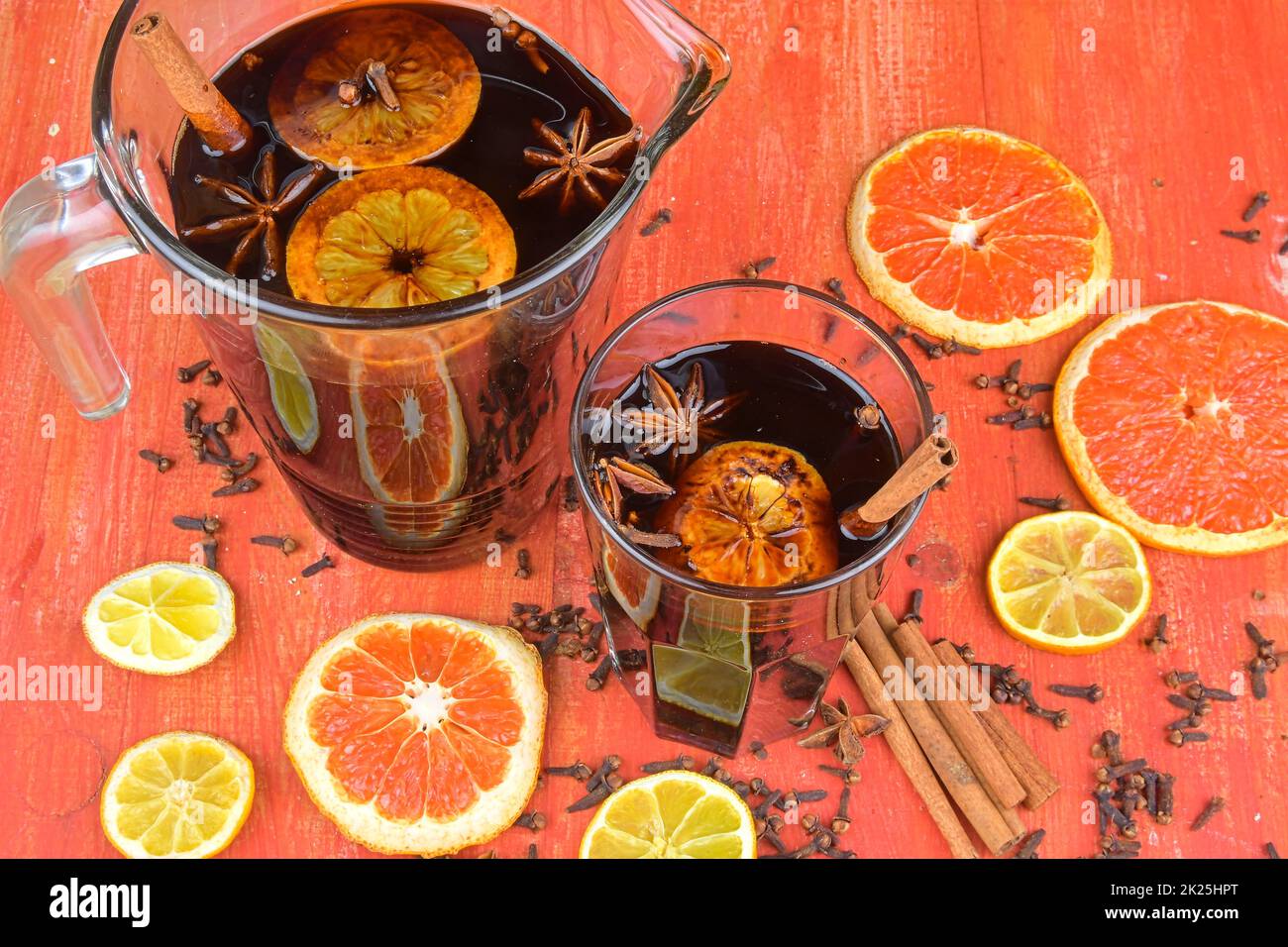 Vin chaud chaud de Noël avec cannelle, clous de girofle et étoile anis sur fond de bois. Vin chaud chaud chaud chaud en hiver et à Noël sur une table rustique en bois. Vin chaud rouge dans une verseuse Banque D'Images