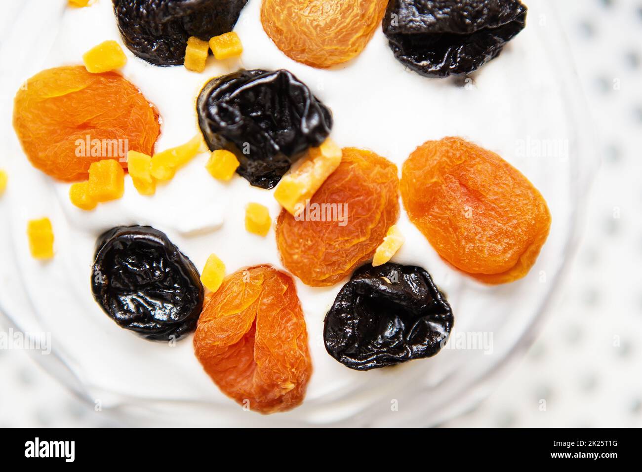 Un gâteau de Pâques décoré d'abricots et de pruneaux séchés se dresse sur un tablier bleu rayé. Concept de vacances religieuses de Pâques. Banque D'Images