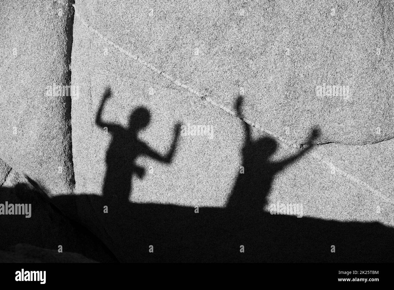 Enfants jouant avec l'ombre à un rocher dans le parc national de Joshua Tree Banque D'Images