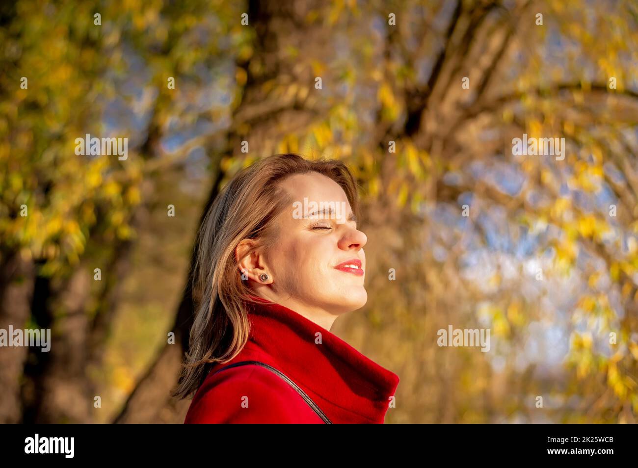 jeune femme qui profite du soleil du soir dans le parc Banque D'Images