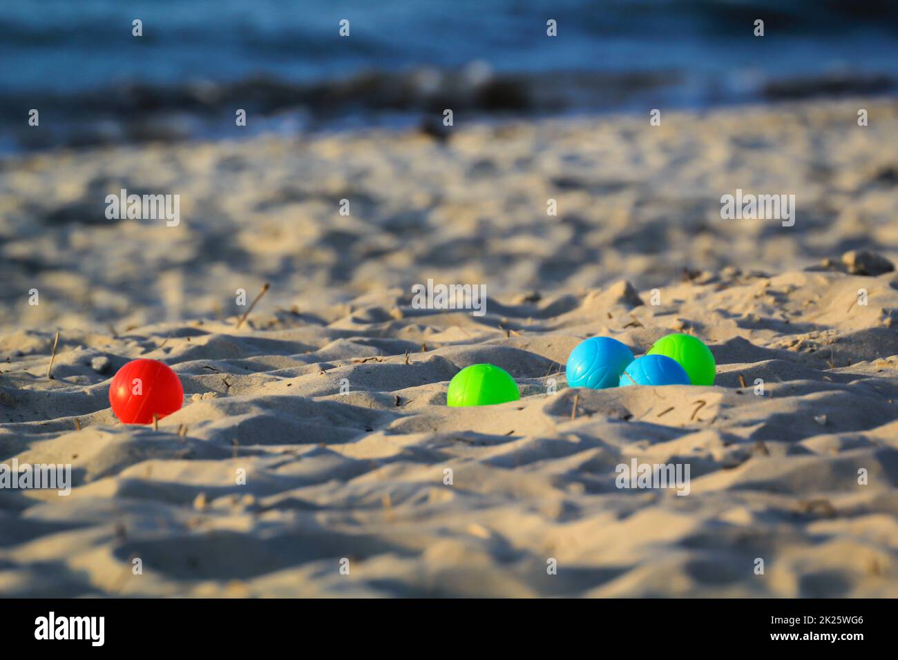 Boules colorées sur la plage. Scène de jeu de boules. Banque D'Images