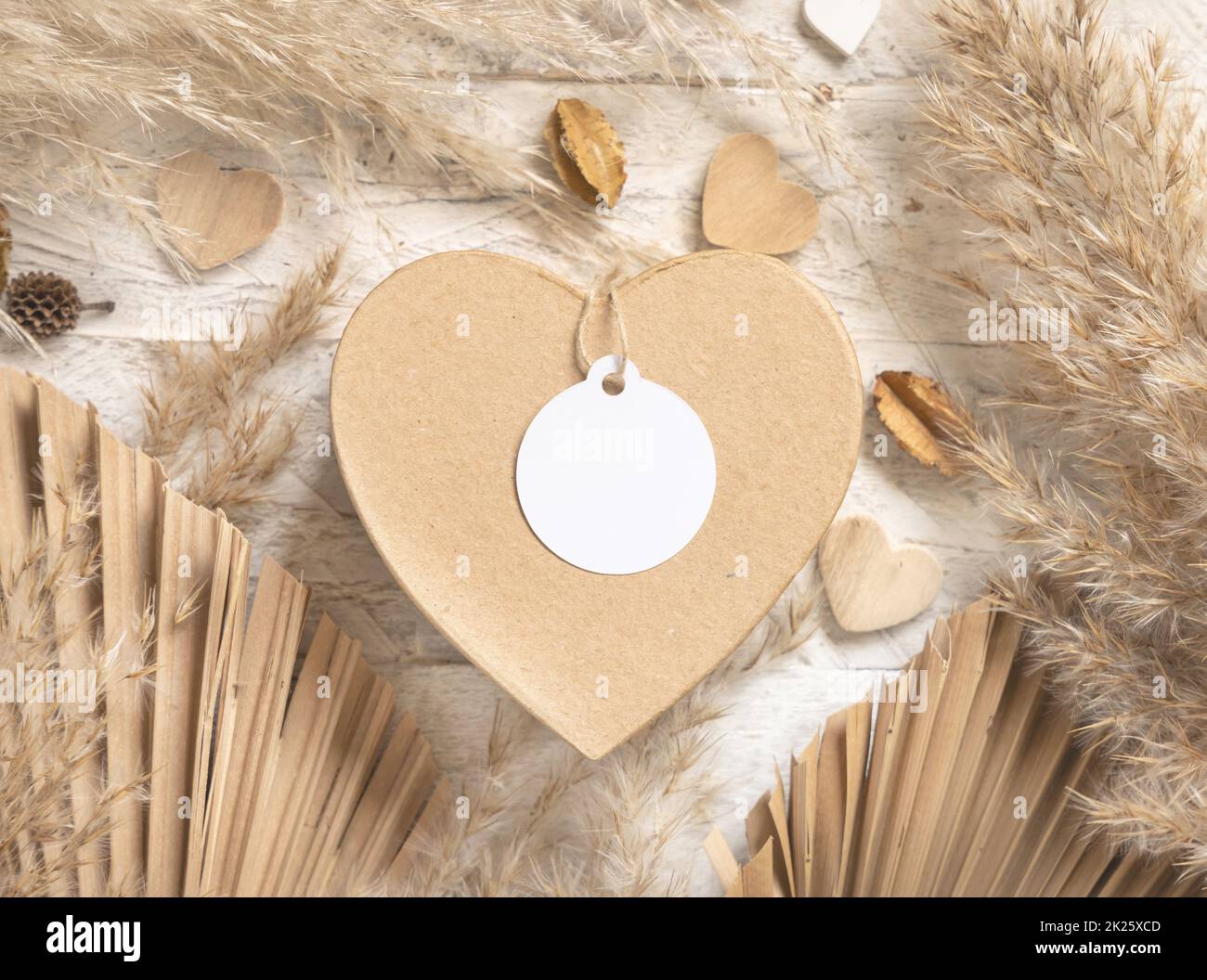 Cadeau de Saint-Valentin en forme de coeur avec étiquette cadeau ronde vierge, herbe et coeurs de pampas, maquette de boho Banque D'Images