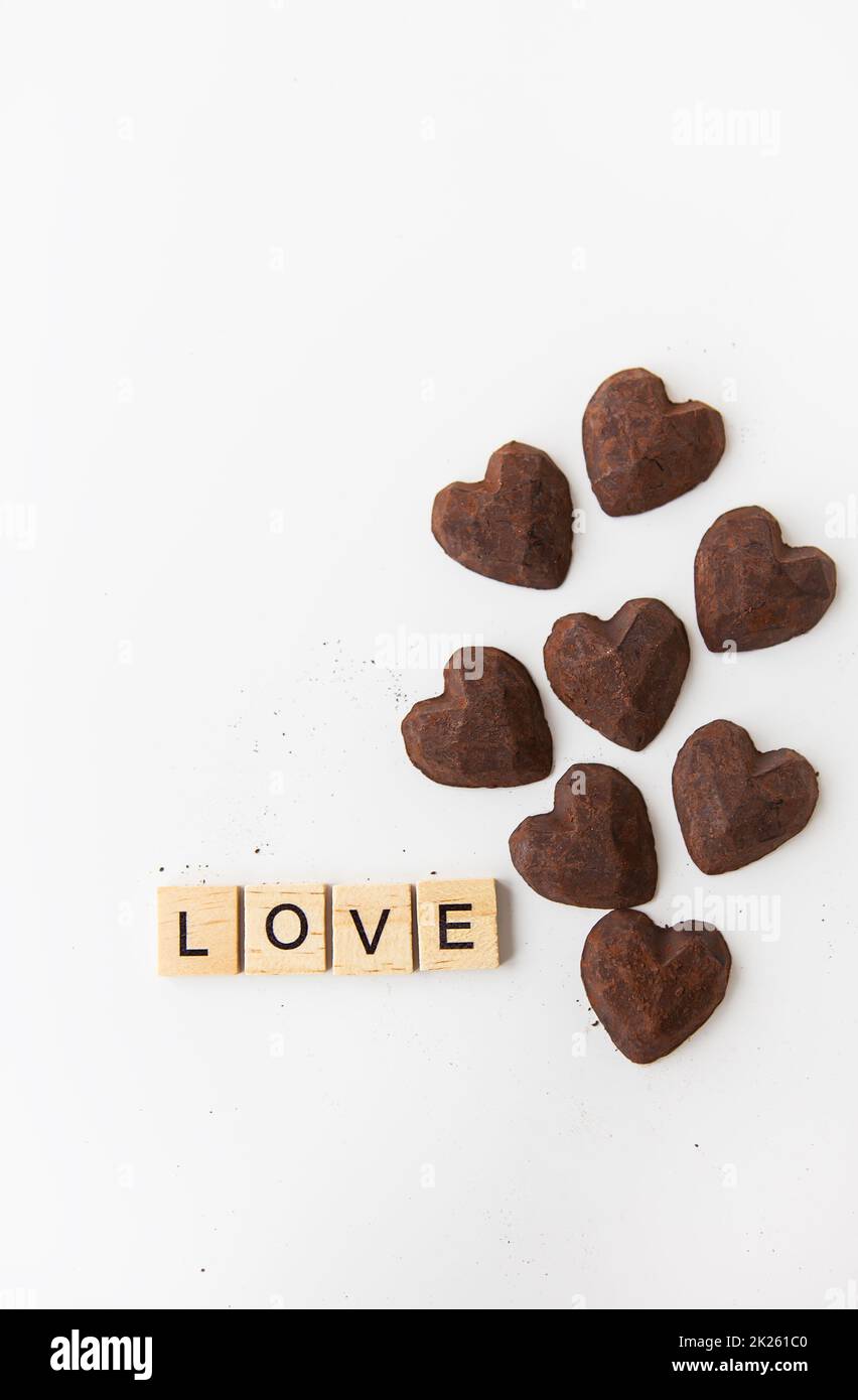 L'inscription en lettres de bois amour, petites bonbons truffes sous forme de coeur. Banque D'Images