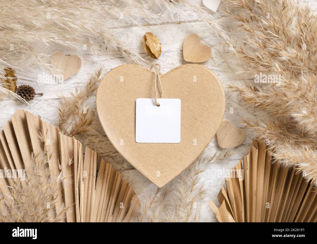 Cadeau de Saint-Valentin en forme de coeur avec étiquette cadeau carrée vierge, herbe et coeurs de pampas, maquette de boho Banque D'Images