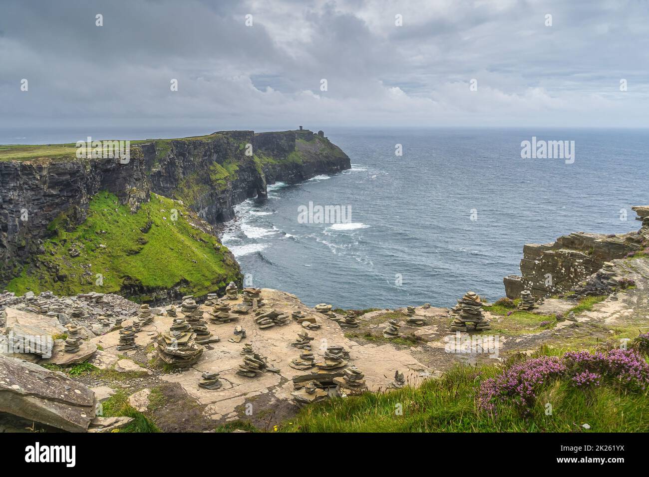 Rock balancing sur le bord des falaises emblématiques de Moher, en Irlande Banque D'Images