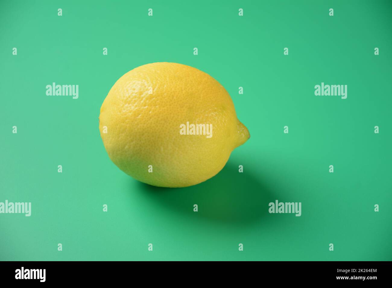 Citron isolé sur fond vert.Le citron est à la fois un petit arbre à feuilles persistantes, originaire d'Asie, et le fruit jaune ovale de l'arbre Banque D'Images