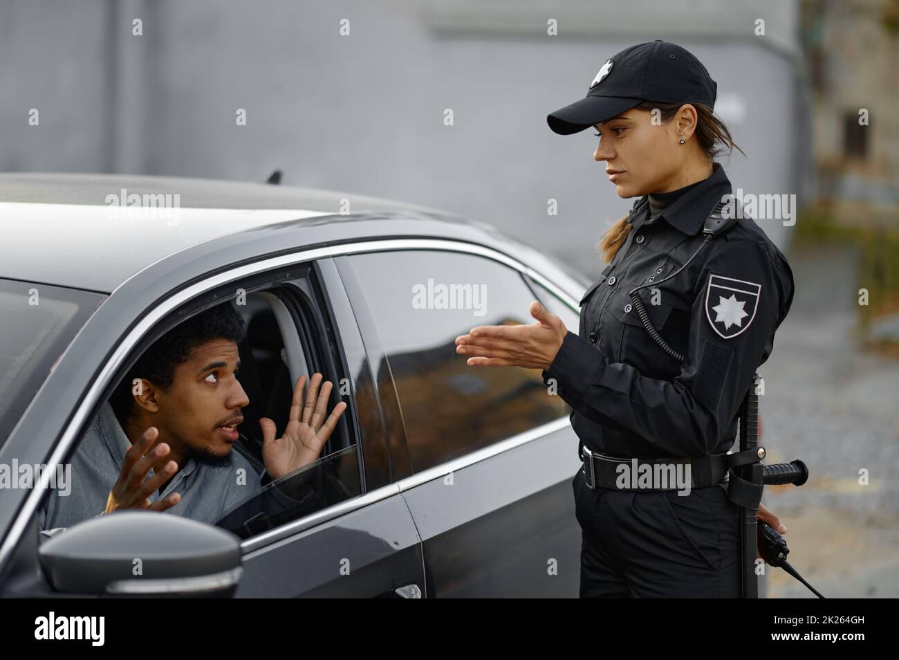 Le conducteur de voiture discute avec une femme de la police de la circulation Banque D'Images