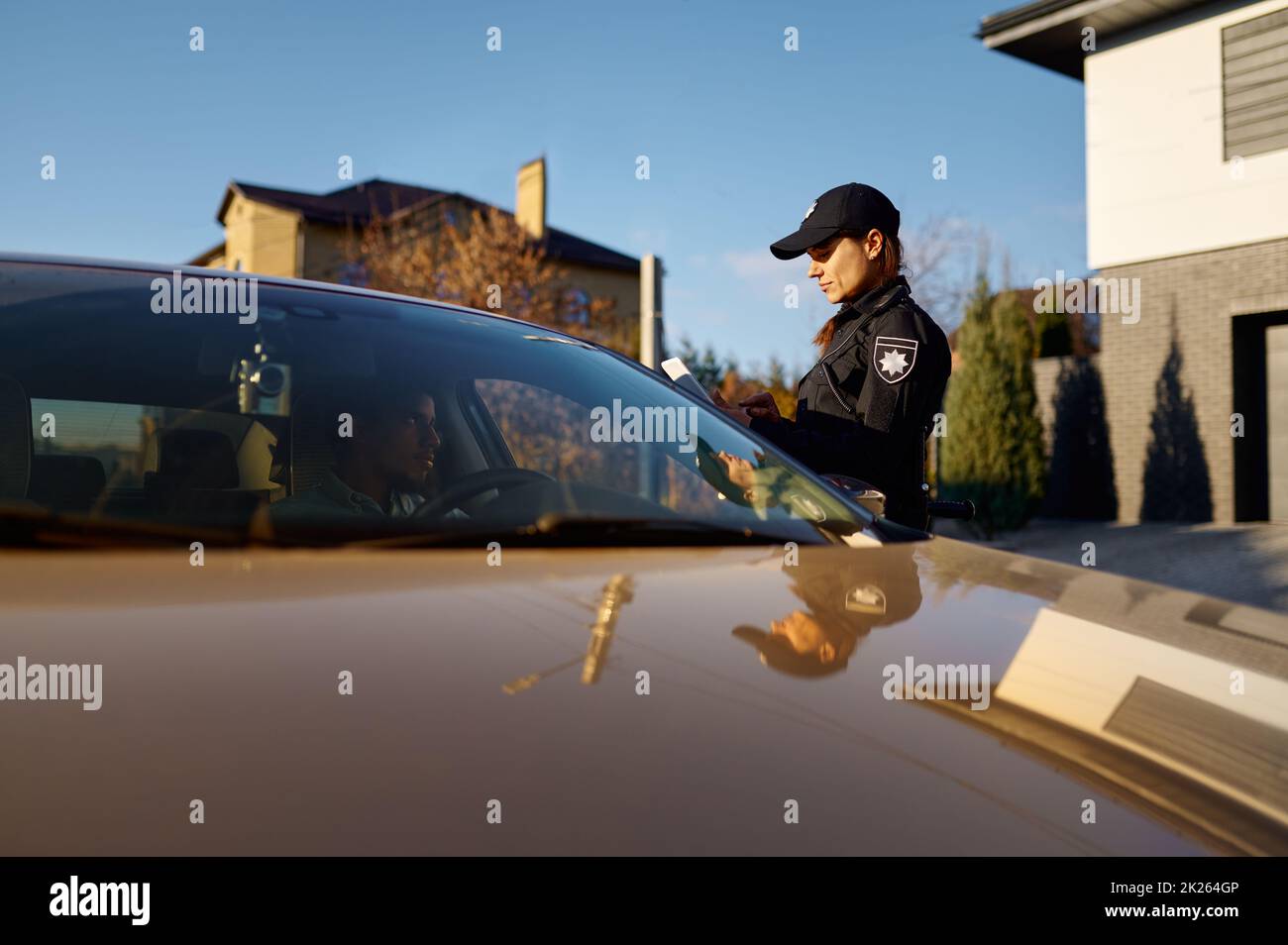 Jeune policier avec tablette debout près de la voiture Banque D'Images