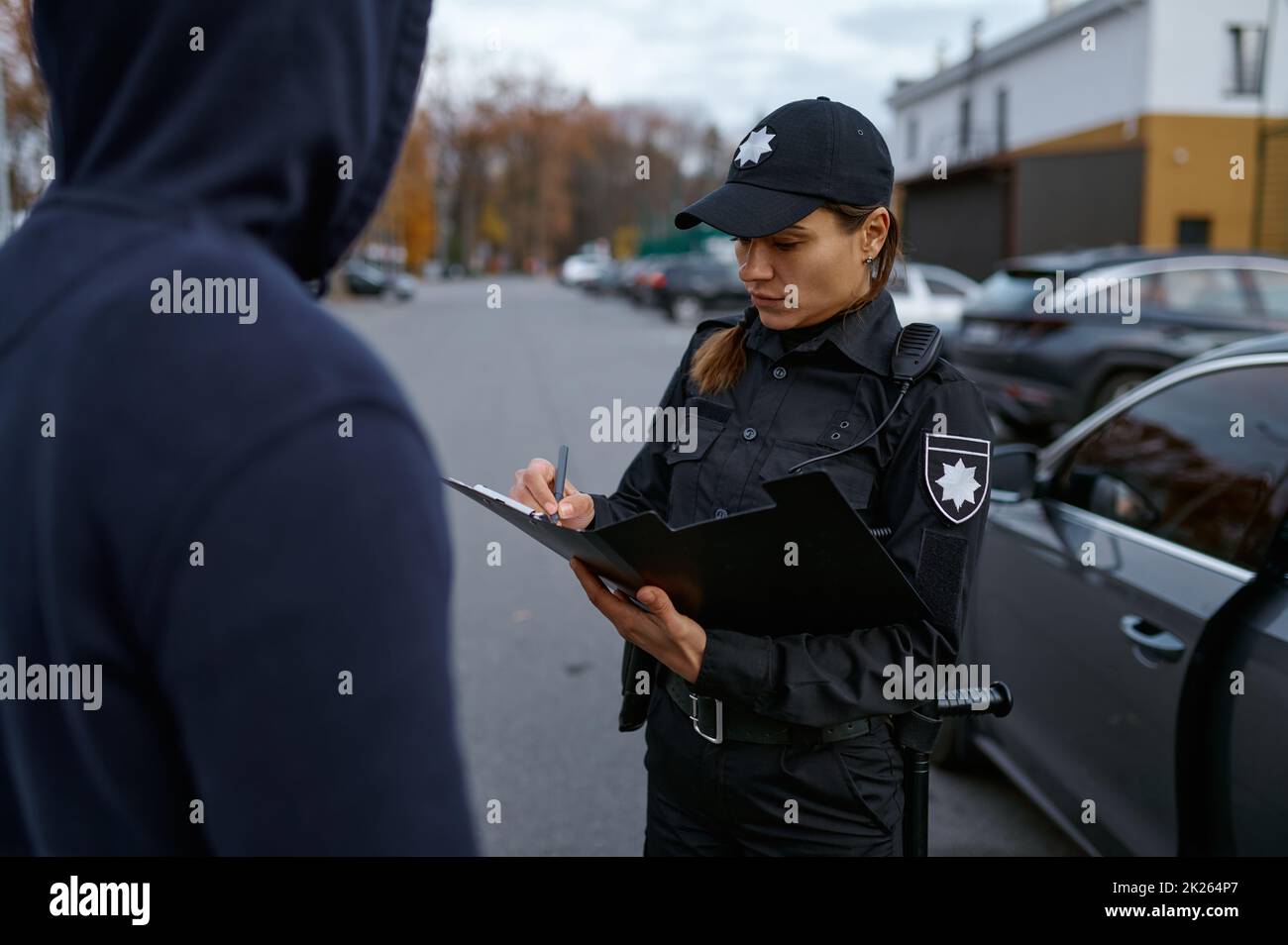 Une femme de police qui émet une amende à l'auteur de l'infraction Banque D'Images