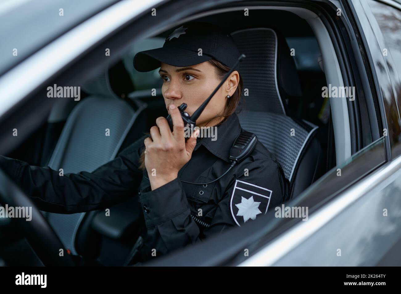 Policier utilisant la radio patrouiller rue en voiture Banque D'Images