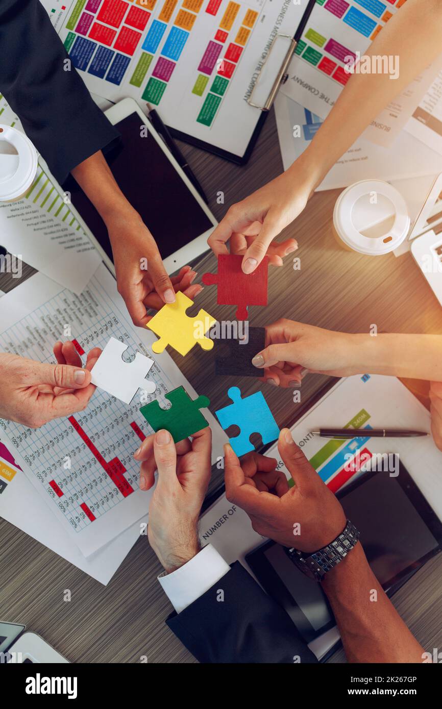 Le travail d'équipe des partenaires relie des pièces de puzzle comme intégration et démarrage Banque D'Images